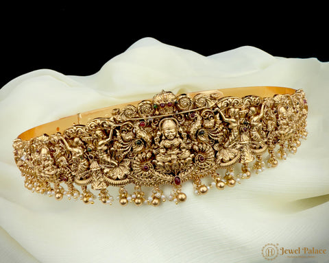 Gold jewelry piece with intricate designs on a white background
