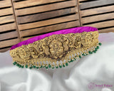 Decorative gold belt with green beads on a white fabric background