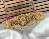 Gold decorative belt with intricate patterns on a white fabric background