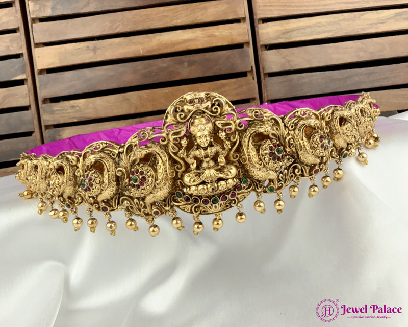 Gold jewelry with purple cushion on a white fabric background