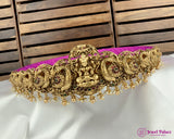 Decorative gold necklace on a white and purple fabric with a wooden background