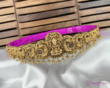 Gold necklace with intricate designs on a white fabric background