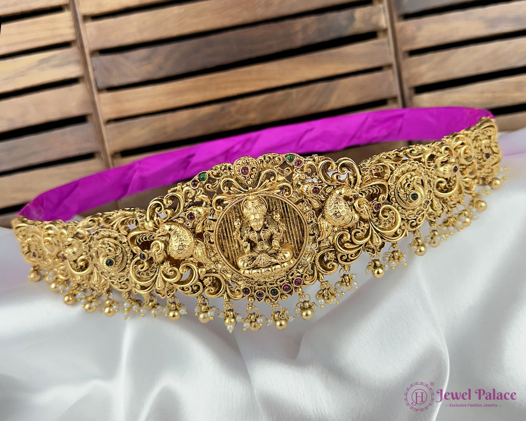 Gold necklace with intricate designs on a white and purple fabric background, branded 'Jewel Palace'.