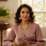 Woman wearing a large necklace in a warm, indoor setting