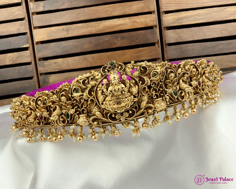 Gold decorative headband with intricate designs on a white surface with wooden background
