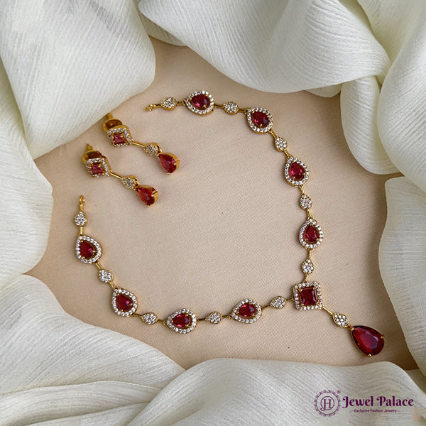 Jewelry set with necklace and earrings on a white fabric background, featuring 'Jewel Palace' brand.