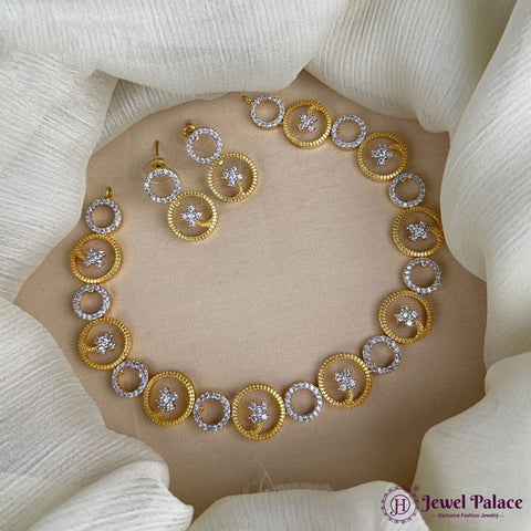 Gold and silver necklace with circular design on a beige surface, brand 'Jewel Palace' visible.