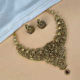 Gold necklace and earrings set on a beige surface