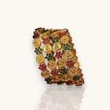 Gold bracelet with embedded coins and gemstones on a white background