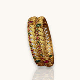 Gold bangle with gemstones on a white background