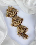 Gold earrings with red gemstones on a white fabric background