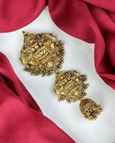 Gold earrings on a red fabric background