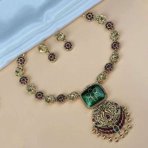 Ornate necklace with green pendant on a mannequin