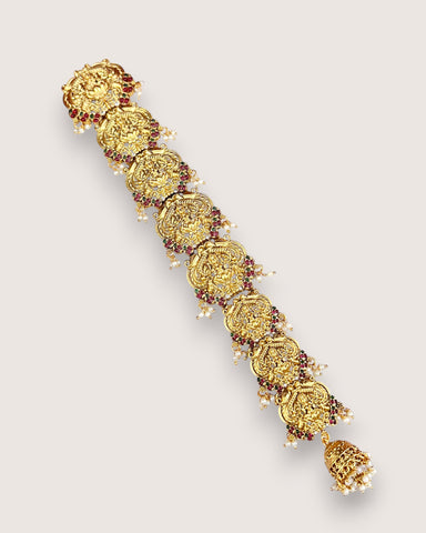 Gold bracelet with decorative elements on a light gray background