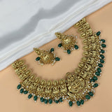 Gold and green jewelry set on a white fabric background