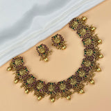 Gold necklace and earrings on a white fabric background