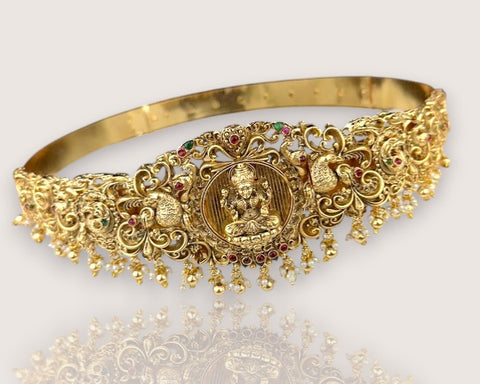 Gold decorative headband with intricate designs and gemstones on a white background