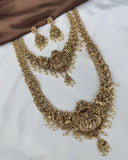 Gold necklace and earrings set on a white surface