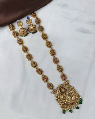 Decorative gold necklace with pendant and matching earrings on a white background