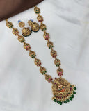 Ornate gold necklace with green and red stones on a white background