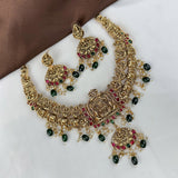 Ornate gold necklace with green and red gemstones on a white surface
