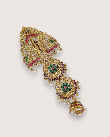 Decorative gold bracelet with gemstones on a light beige background