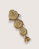 Gold necklace with red and green gemstones on a light gray background