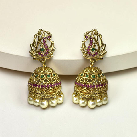 Gold jhumka earrings with pearls and gemstones on a white background