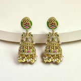 Ornate gold earrings with green and red gemstones on a white background