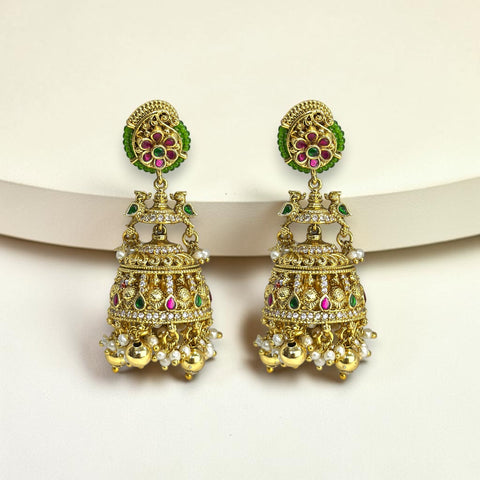 Ornate gold earrings with green and red gemstones on a white background