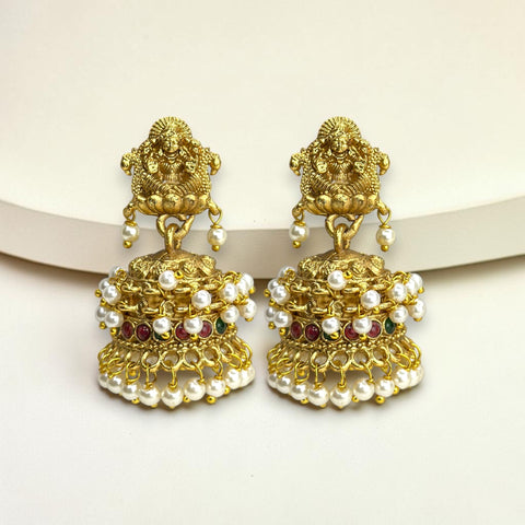 Gold earrings with pearls and red stones on a white background