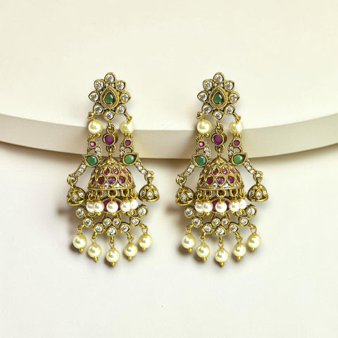 Ornate gold earrings with pearls and gemstones on a white background