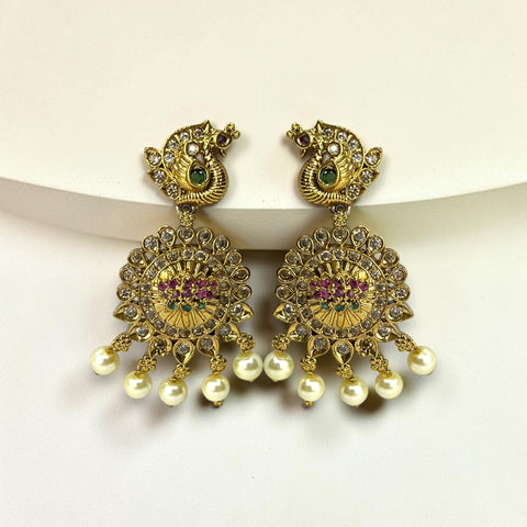Gold earrings with pearls and gemstones on a white background