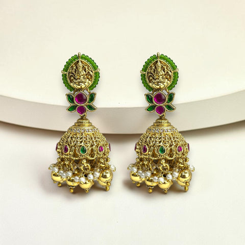 Gold earrings with green and red gemstones on a white background