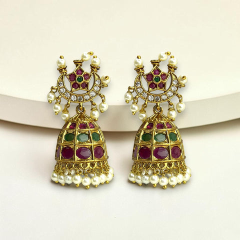 Ornate gold earrings with gemstones and pearls on a white background