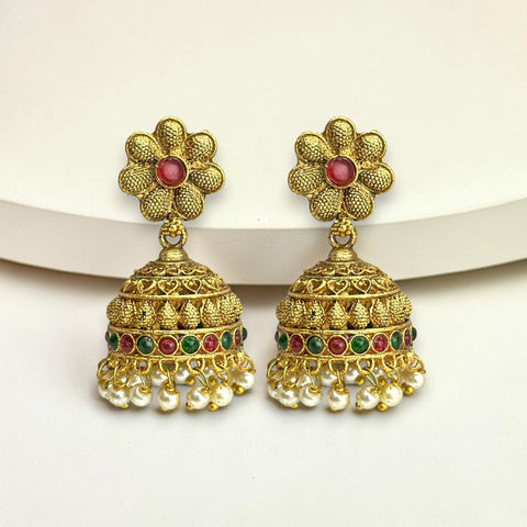 Gold floral earrings with red and green stones on a white background