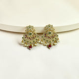 Gold earrings with green and red stones on a white background