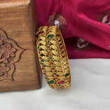 Gold bracelet with gemstones on a wooden box