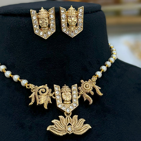 Gold necklace and earrings set on a black stand