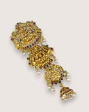 Decorative gold earring with gemstones on a light gray background