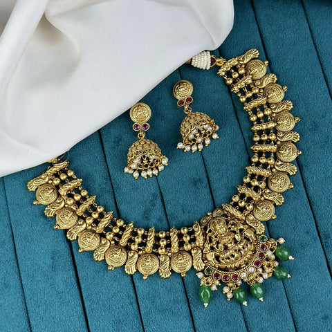 Gold necklace and earrings on a blue fabric background