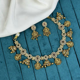 Gold necklace and earrings set on a blue fabric background