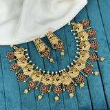 Gold necklace and earrings set on a blue fabric background