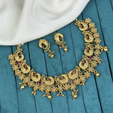 Gold necklace and earrings set on a blue surface
