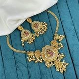 Gold necklace with pink gemstones on a blue wooden surface