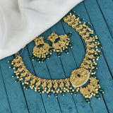 Gold necklace and earrings on a blue wooden surface