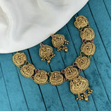 Gold necklace with intricate designs on a blue fabric background