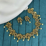 Gold necklace and earrings on a teal fabric background