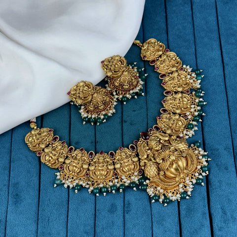 Gold necklace and earrings on a blue fabric background