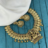 Gold necklace with intricate designs on a blue fabric background